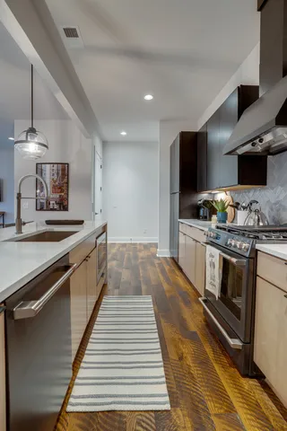 a kitchen with stainless steel appliances kitchen island granite countertop a stove and a sink