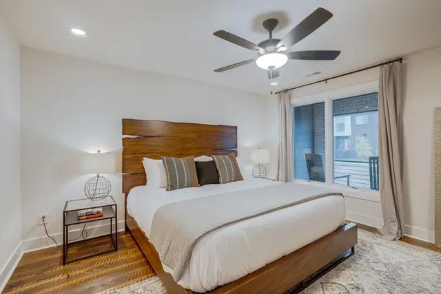 a bedroom with a large bed and a ceiling fan