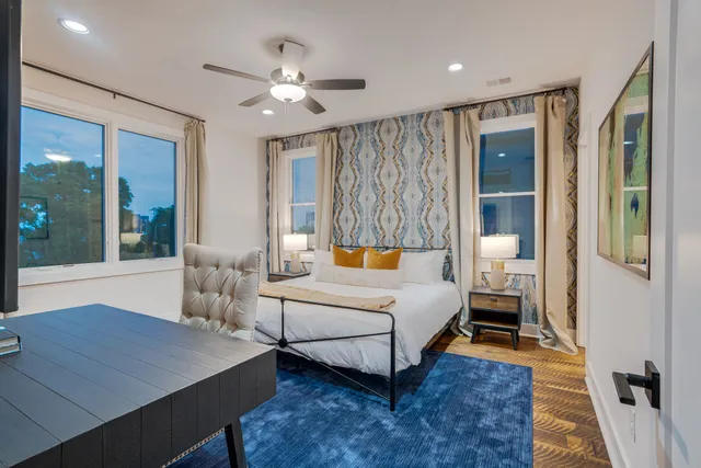 a bedroom with a bed wooden floor and window