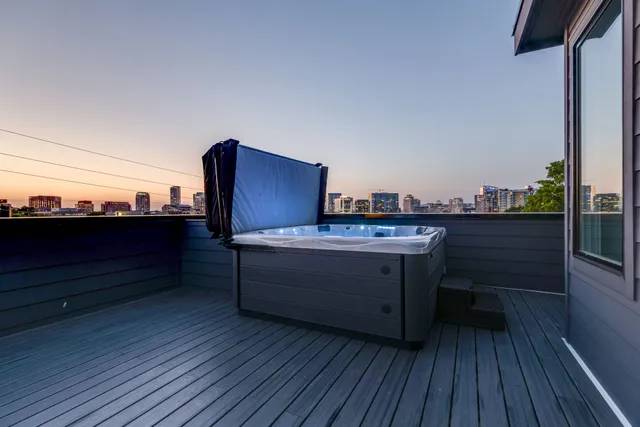 a view of a roof deck with table and chairs couches with wooden floor and fence