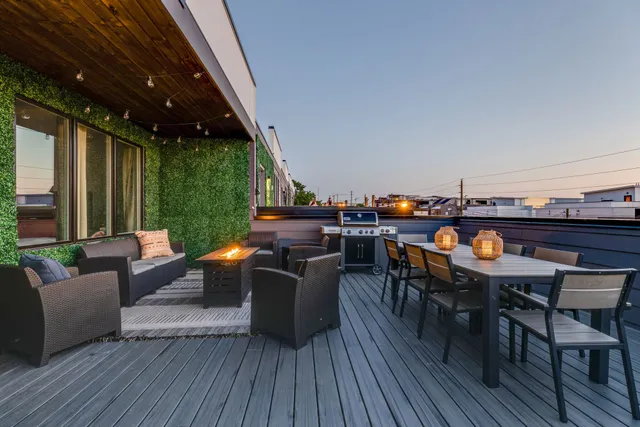 a view of a deck with table and chairs couches with wooden floor and fence