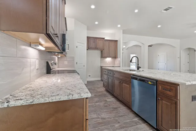 a open kitchen with kitchen island a sink stainless steel appliances and cabinets