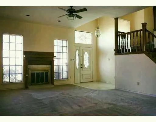 an empty room with windows and fireplace