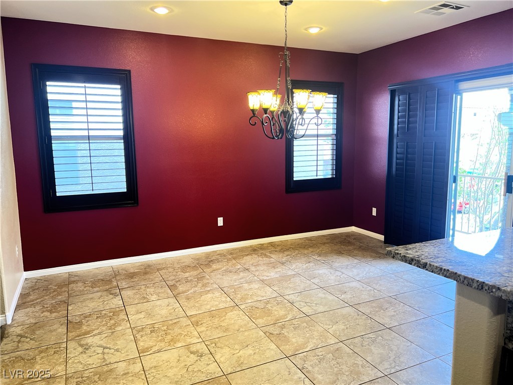 9535 Leaping Lizard Street Las Vegas, NV 89178 - Photo 6 of 37 Dining area just off the kitch with a chandelier, shutters a balcony and plenty of natural light