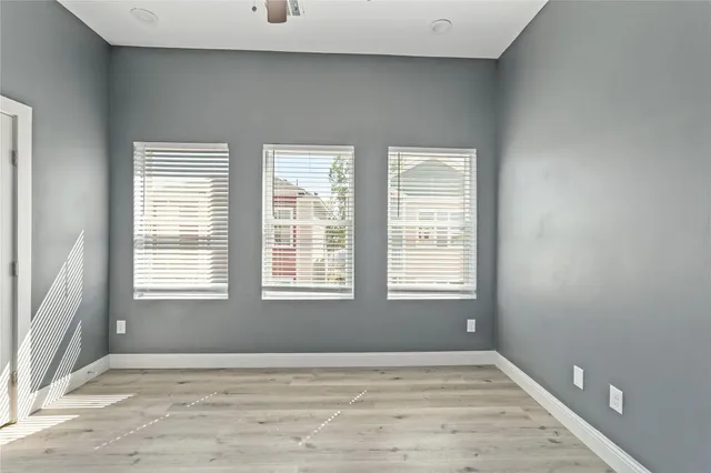 an empty room with a window and a ceiling fan