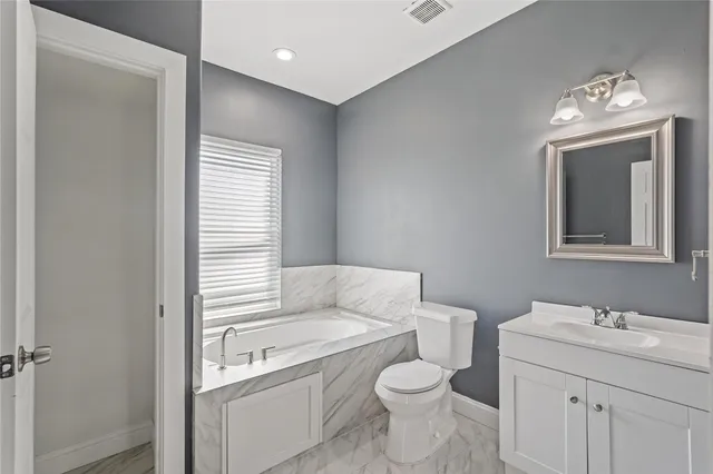 a bathroom with a sink a toilet and a large mirror