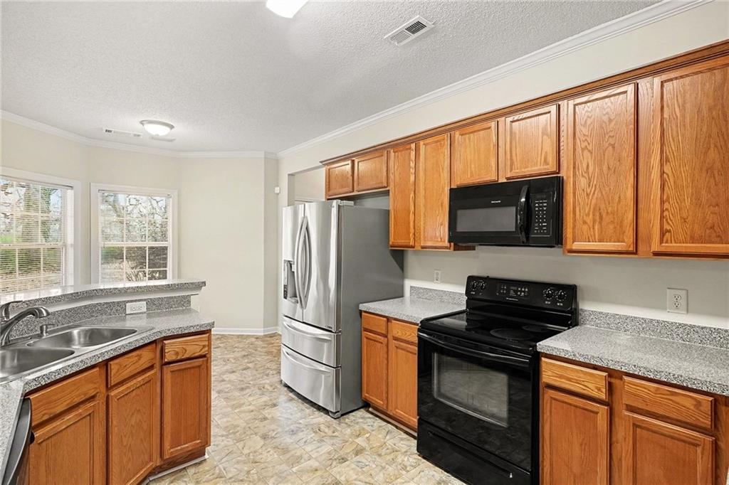 1558 Kilgore Road Griffin, GA 30223 - Photo 12 of 32 a kitchen with stainless steel appliances a stove sink microwave and refrigerator