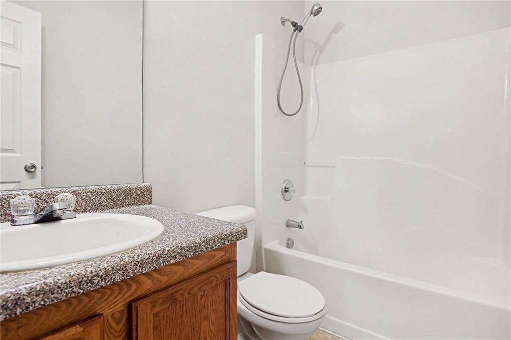 1558 Kilgore Road Griffin, GA 30223 - Photo 28 of 32 a bathroom with a granite countertop sink a toilet and shower