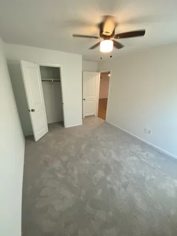 an empty room with a ceiling fan and bathroom