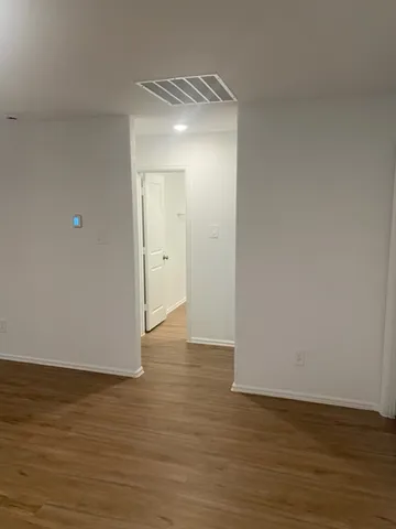 a view of an empty room and wooden floor