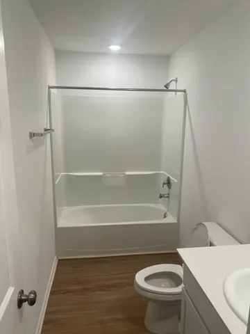 a white toilet sitting next to a bath tub