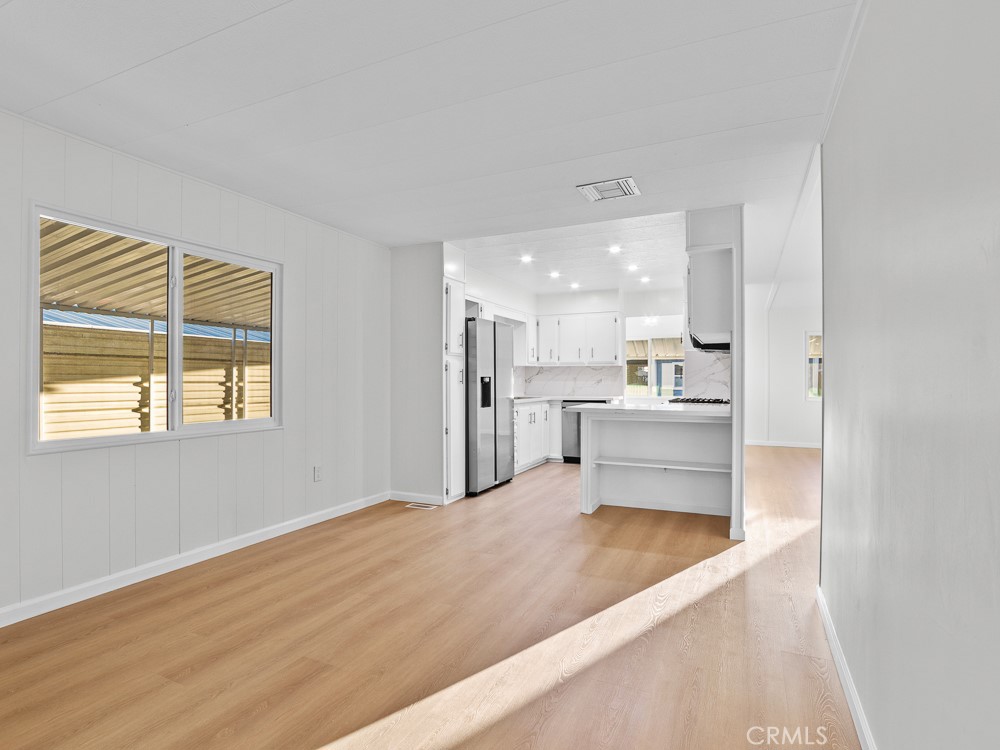 8301 Mission Gorge Road, Unit 172 Santee, CA 92071 - Photo 13 of 30 a large white kitchen with kitchen island a sink stainless steel appliances and cabinets