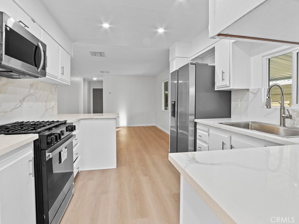 8301 Mission Gorge Road, Unit 172 Santee, CA 92071 - Photo 6 of 30 a kitchen with stainless steel appliances granite countertop a sink stove and refrigerator