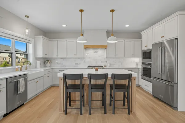 a kitchen with white cabinets and a refrigerator