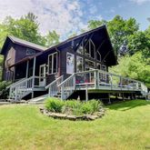 a view of a house with a big yard plants and large trees