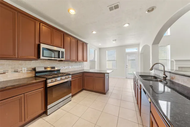 a kitchen with stainless steel appliances granite countertop a sink stove and cabinets