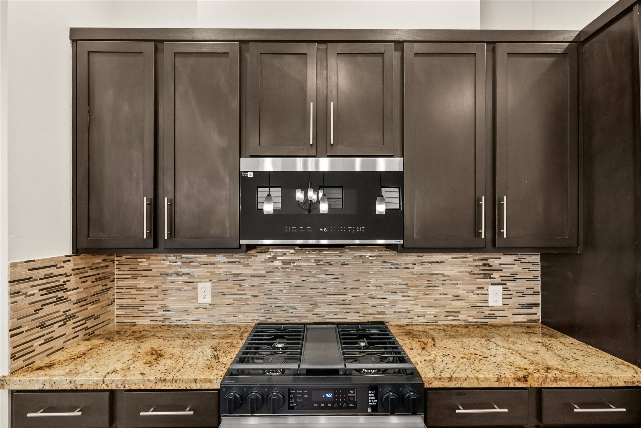 4409 Schuler Street, Unit A Houston, TX 77007 - Photo 15 of 33 The kitchen offers dark wood cabinetry with brushed nickel hardware, and a recently upgraded Samsung gas range, and a built-in microwave above the cooktop.