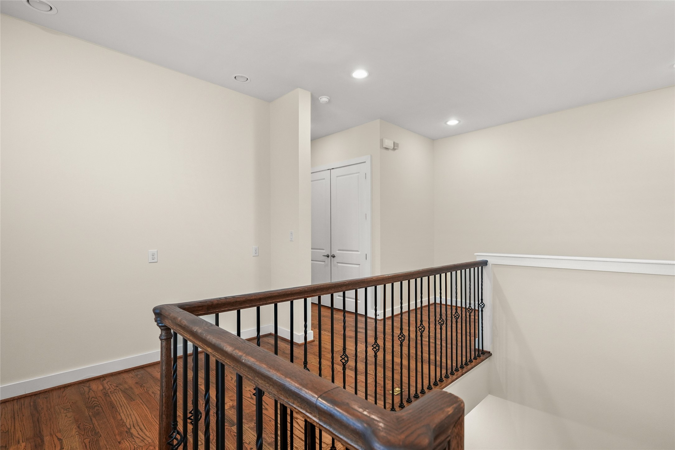 4409 Schuler Street, Unit A Houston, TX 77007 - Photo 17 of 33 Second-floor landing with hardwood floors, stairwell view, and double-door closet for storage.
