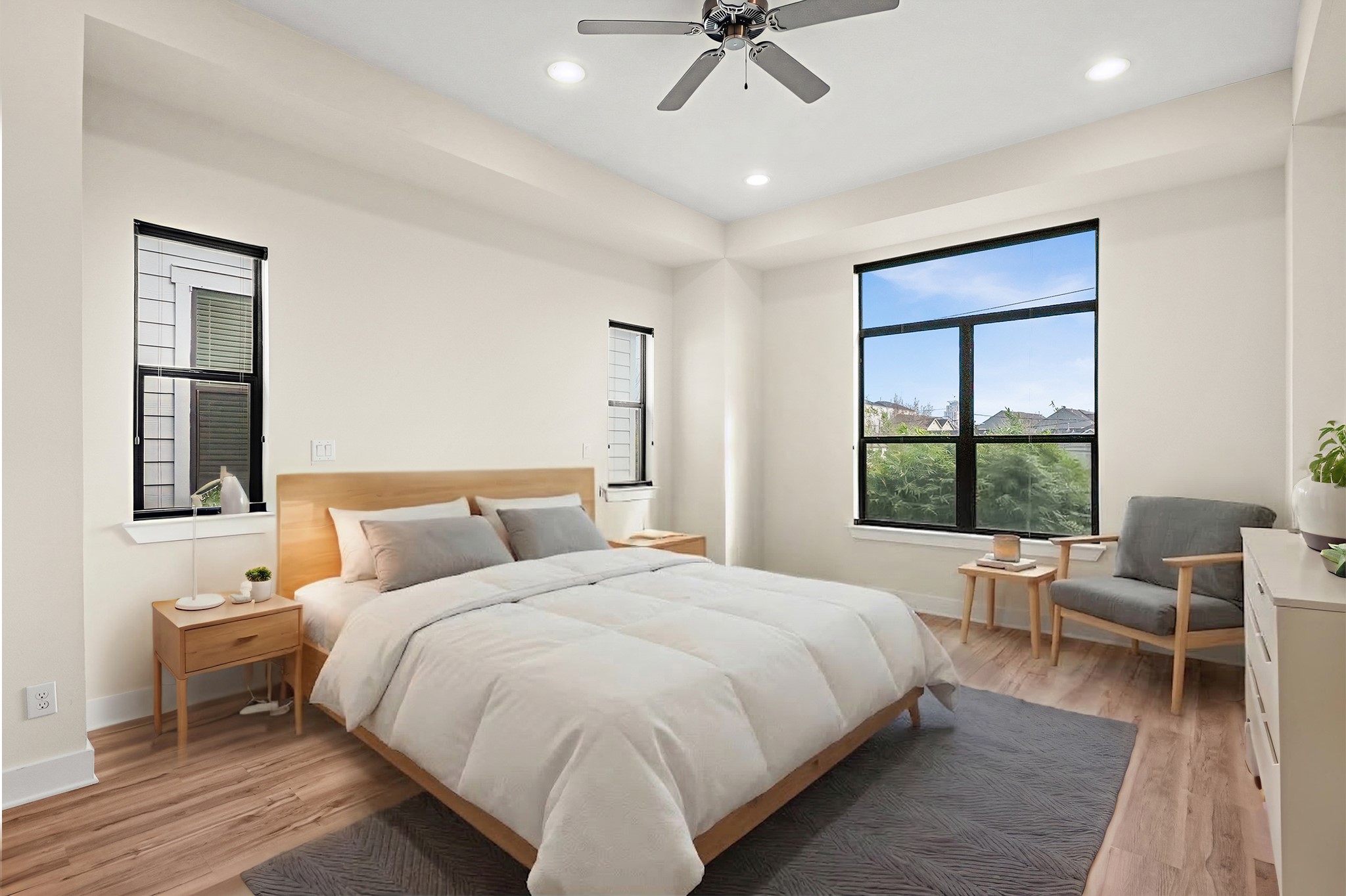 4409 Schuler Street, Unit A Houston, TX 77007 - Photo 20 of 33 Primary bedroom offers wood-style flooring, a recessed ceiling with fan, three large windows, and a private location away from secondary bedrooms for added privacy.**This room has been virtually staged.