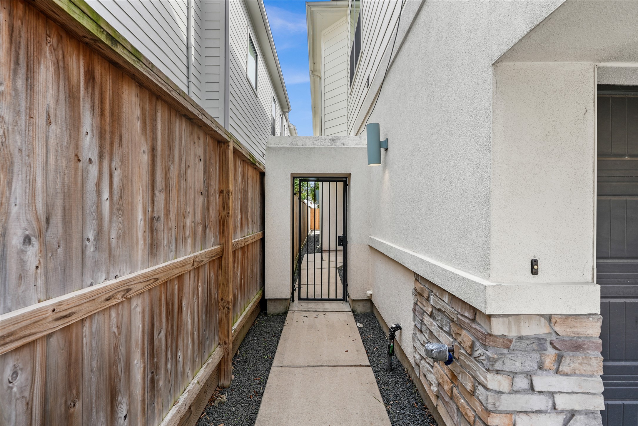 4409 Schuler Street, Unit A Houston, TX 77007 - Photo 3 of 33 Side exterior walkway featuring a concrete path, gravel, and a metal security gate.