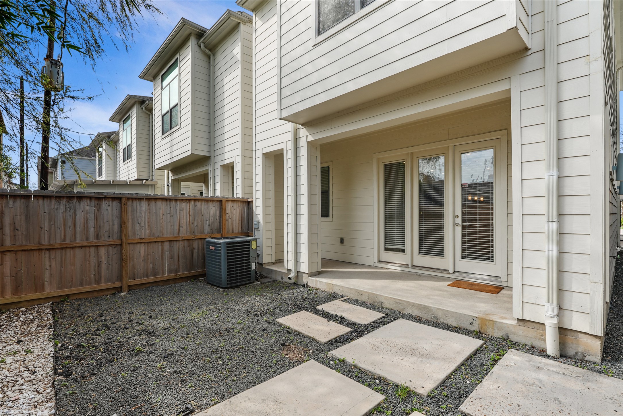 4409 Schuler Street, Unit A Houston, TX 77007 - Photo 5 of 33 Fenced backyard area with a covered concrete patio and gravel landscaping with stepping stones. Glass doors provide access to the interior.