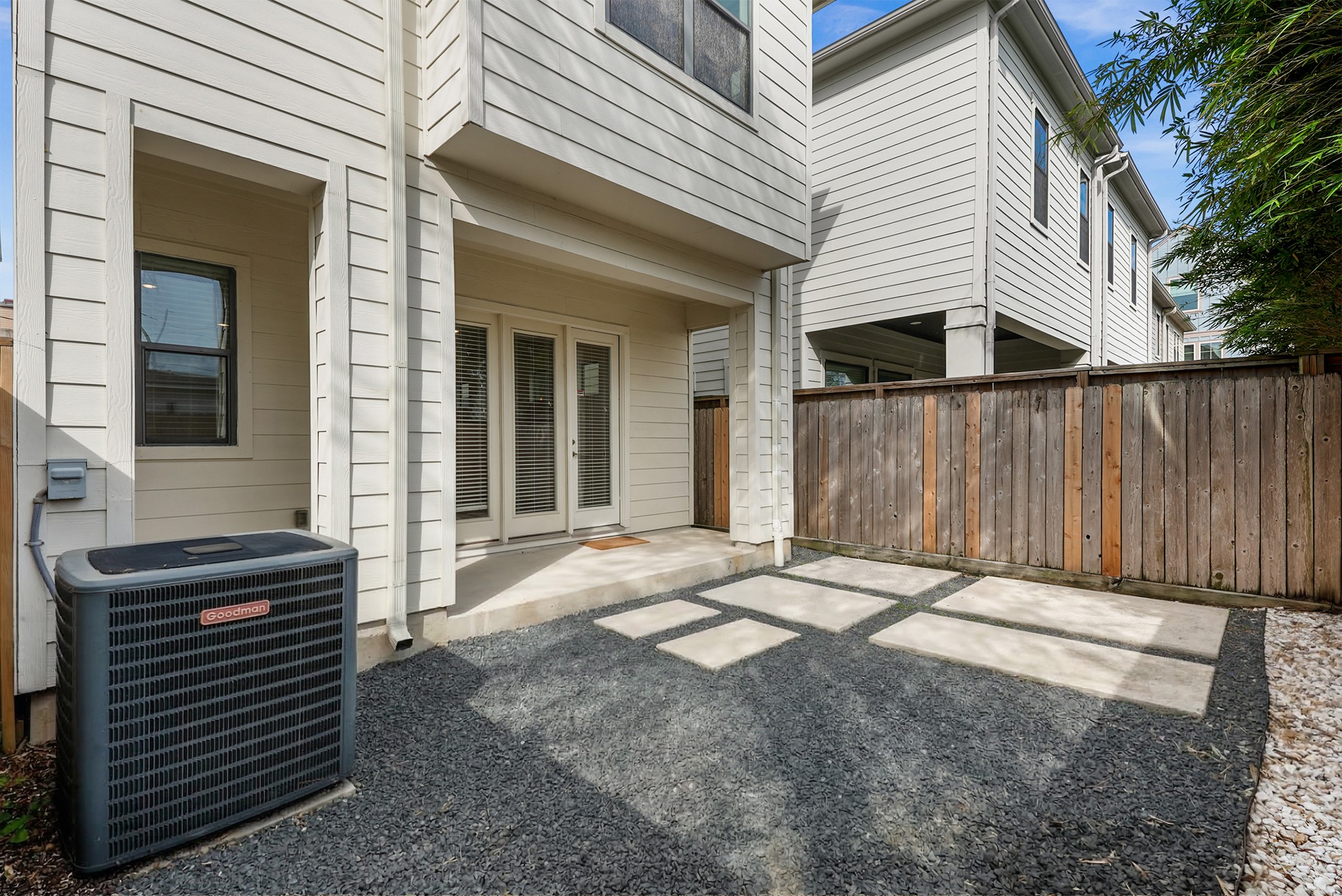 4409 Schuler Street, Unit A Houston, TX 77007 - Photo 6 of 33 Rear exterior view showing the covered patio space, exterior HVAC unit, and wooden privacy fencing.