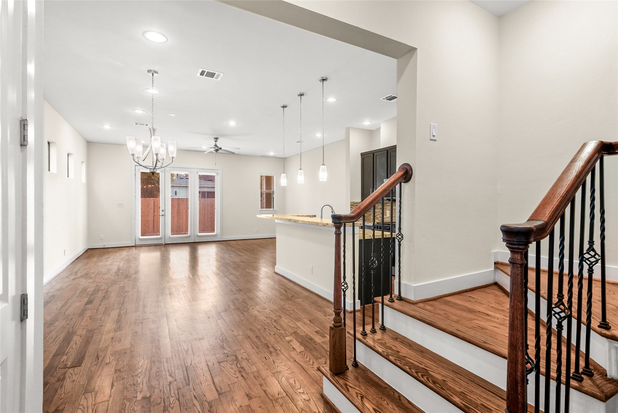 4409 Schuler Street, Unit A Houston, TX 77007 - Photo 33 of 33 The open-concept floor plan showcases wood flooring throughout the living area and a wooden staircase with wrought iron spindles.