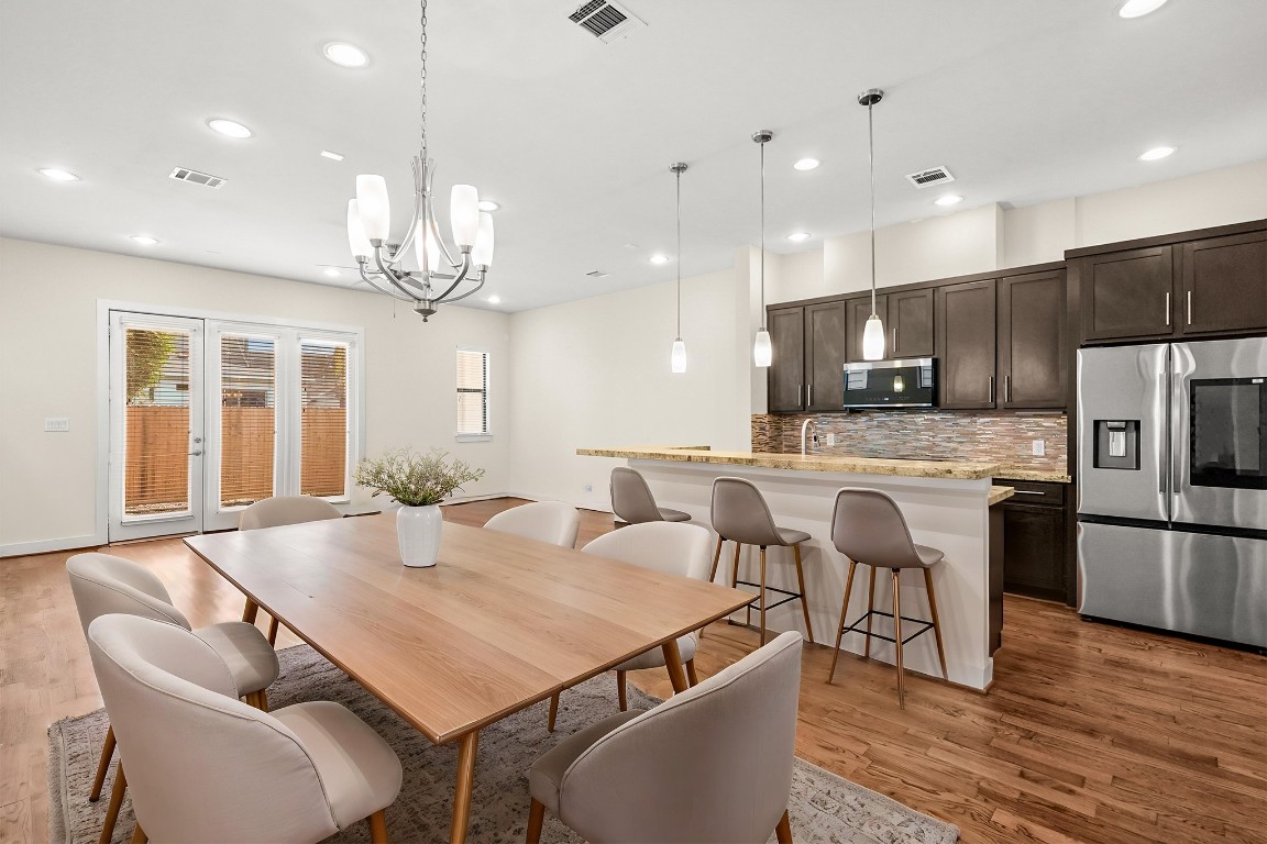 4409 Schuler Street, Unit A Houston, TX 77007 - Photo 9 of 33 The dining and living area offers an expansive layout with neutral walls and wood floors, with French doors featuring built-in blinds that open to the rear outdoor space. **This room has been virtually staged.