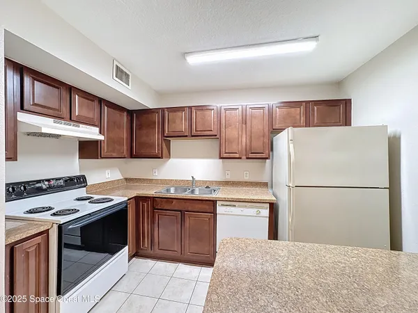 an empty room with chandelier fan and windows
