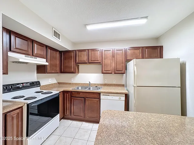 an empty room with chandelier fan and windows