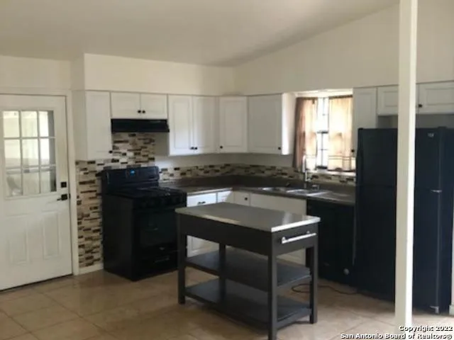 a kitchen with a sink stove and cabinets