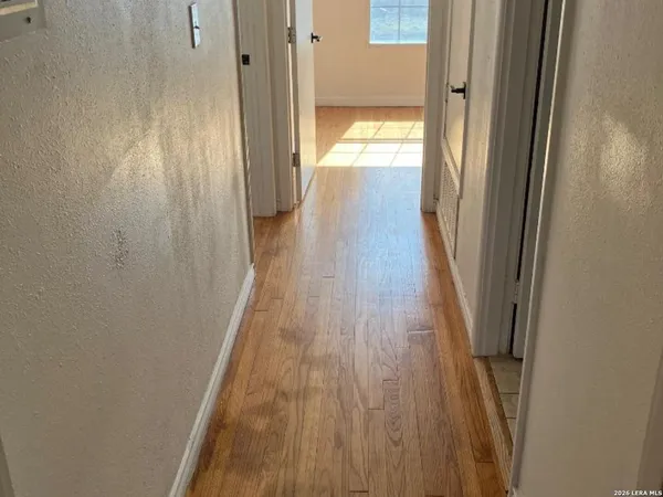 a view of a hallway with wooden floor