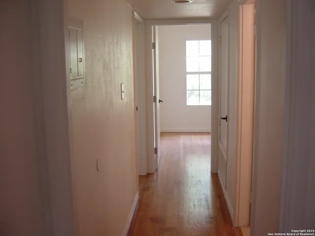 a view of a hallway with wooden floor