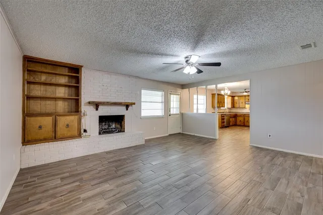 a view of an empty room with a fireplace and a window