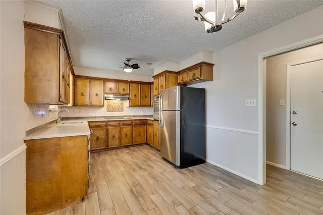 a kitchen with stainless steel appliances a sink cabinets and wooden floor