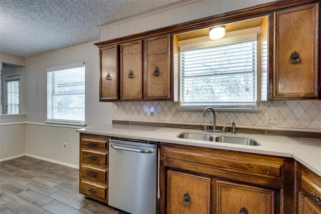 a kitchen with stainless steel appliances sink cabinets and window