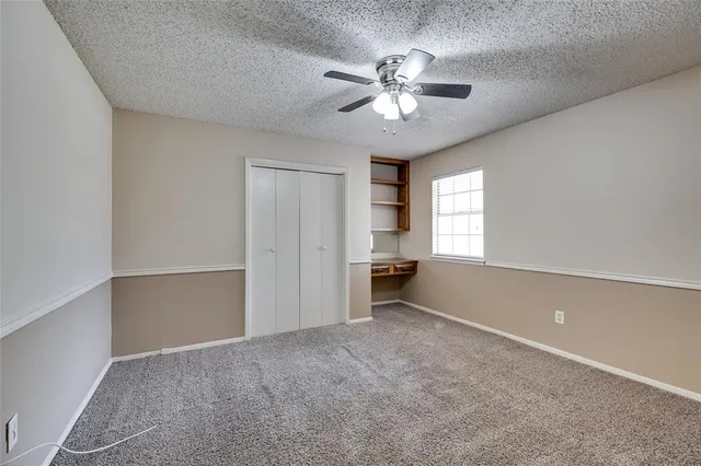 a view of a room with a ceiling fan and window