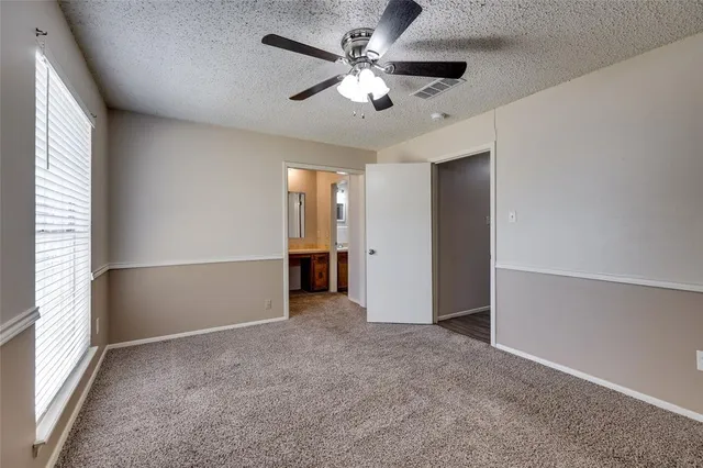 an empty room with fan and windows