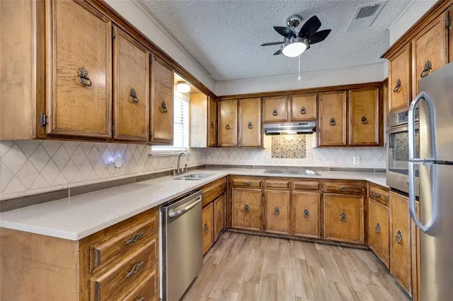 a kitchen with stainless steel appliances granite countertop a sink a stove and refrigerator