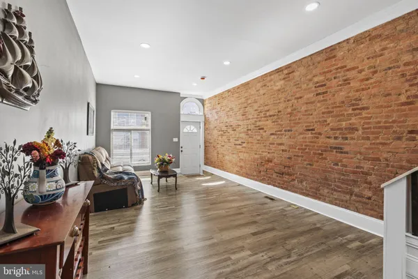 a living room with couches rug and a kitchen view