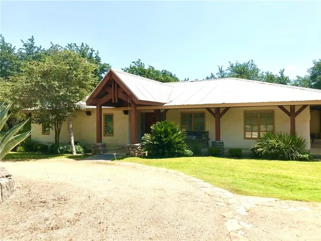 a front view of house with yard and trees in the background