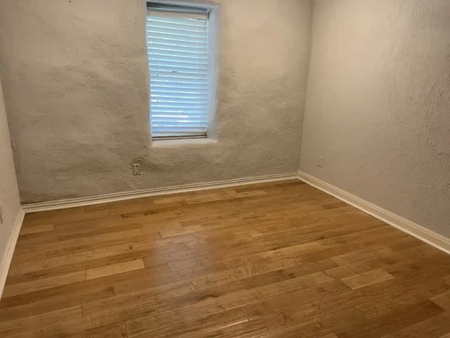 a view of a room with wooden floor and a window