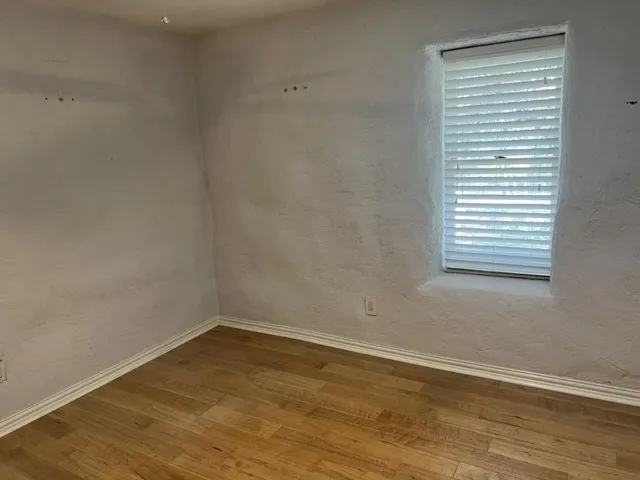 a view of a small space with wooden floor and a window