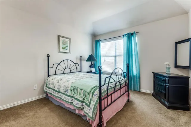 a bed sitting in a bedroom next to a window