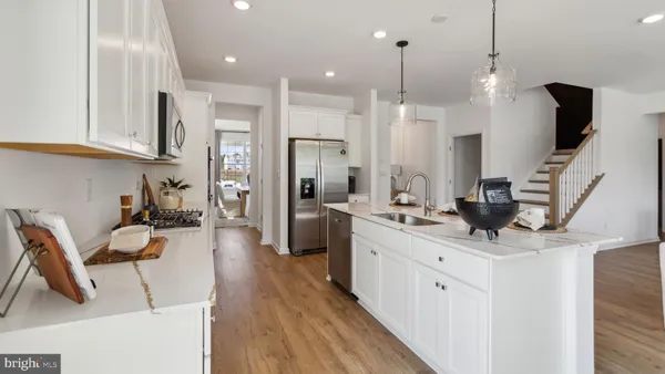 a large white kitchen with sink and refrigerator