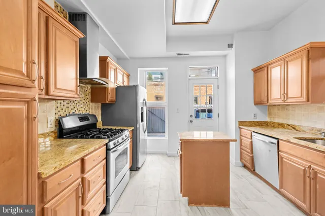 a kitchen with stainless steel appliances granite countertop a stove and a refrigerator