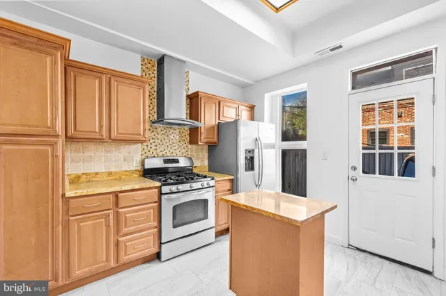 a kitchen with stainless steel appliances granite countertop a refrigerator and a stove