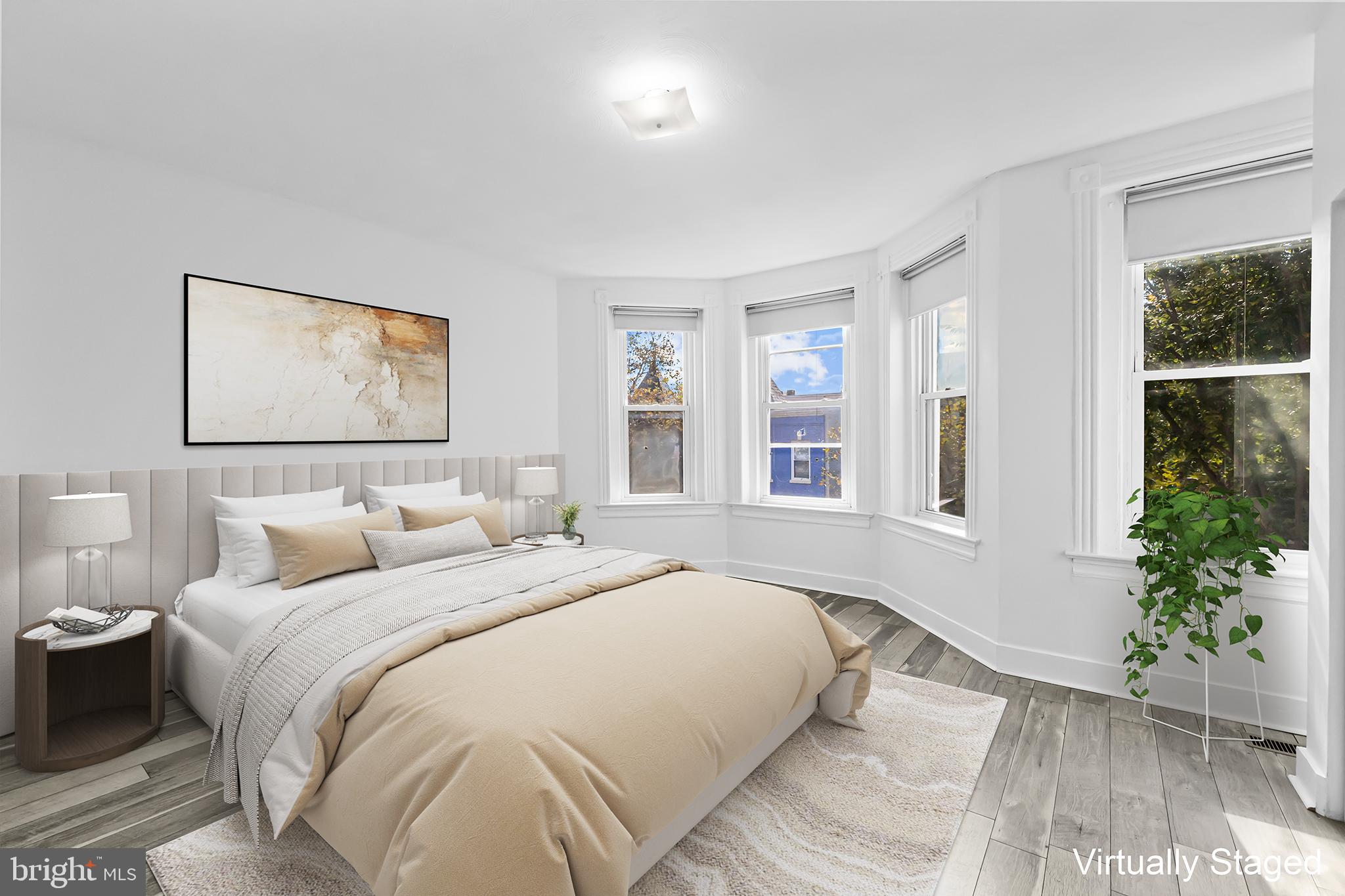 1021 Columbia Road Northwest Washington, DC 20001 - Photo 19 of 55 a bedroom with a large bed and a potted plant
