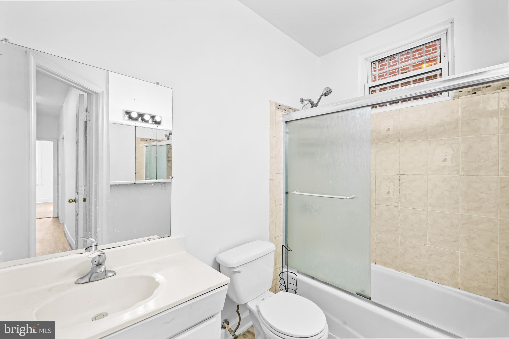 1021 Columbia Road Northwest Washington, DC 20001 - Photo 25 of 55 a bathroom with a sink toilet a mirror and shower