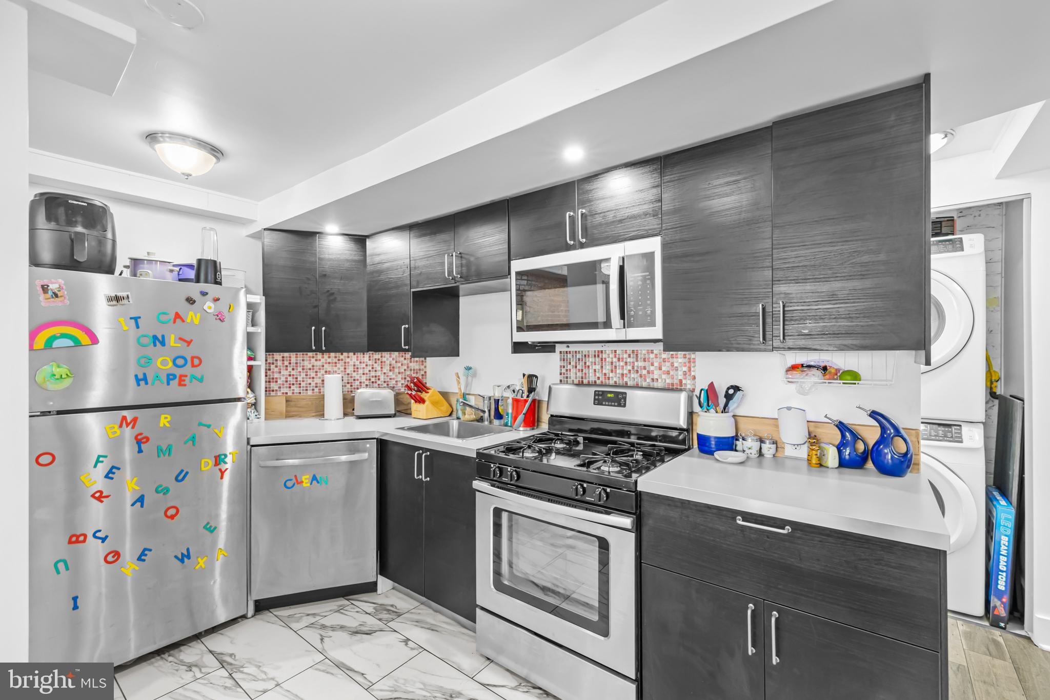 1021 Columbia Road Northwest Washington, DC 20001 - Photo 31 of 55 a kitchen with stainless steel appliances a stove a sink and a refrigerator